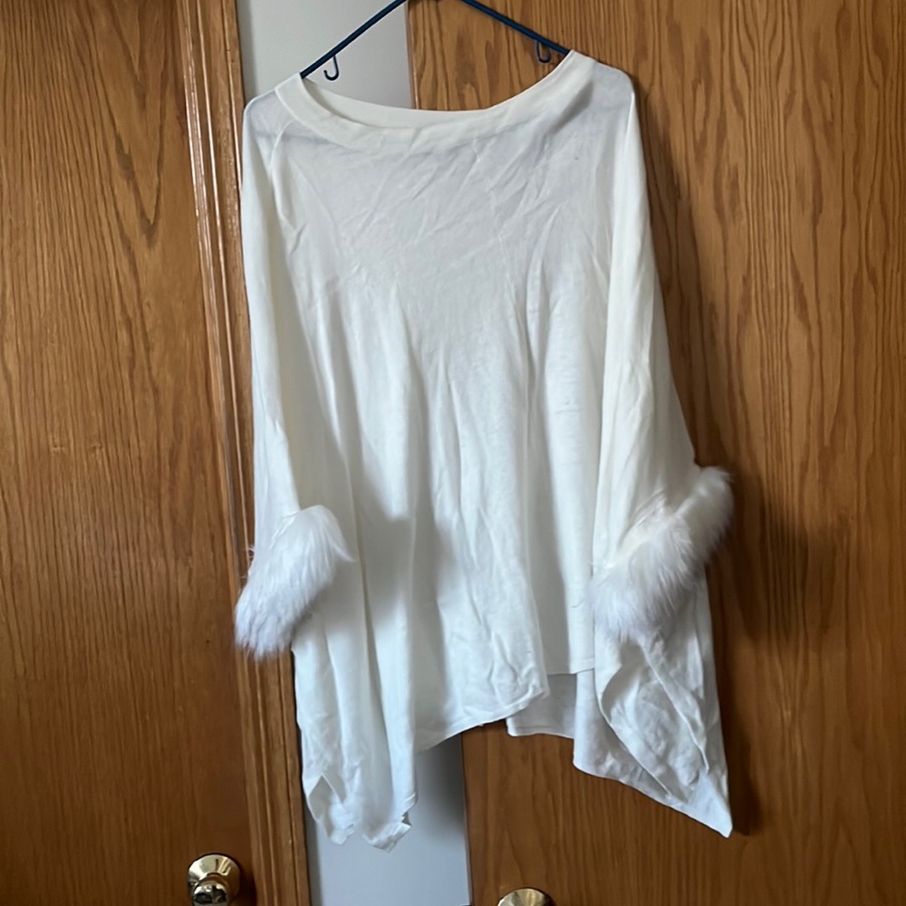 White poncho with feathered sleeves.